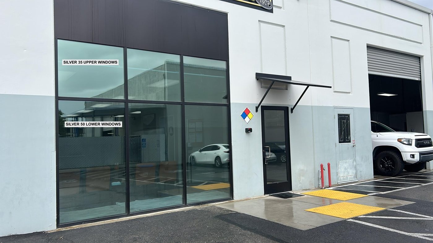 Dark solar control window film installed on the glass entry and storefront windows of a commercial office